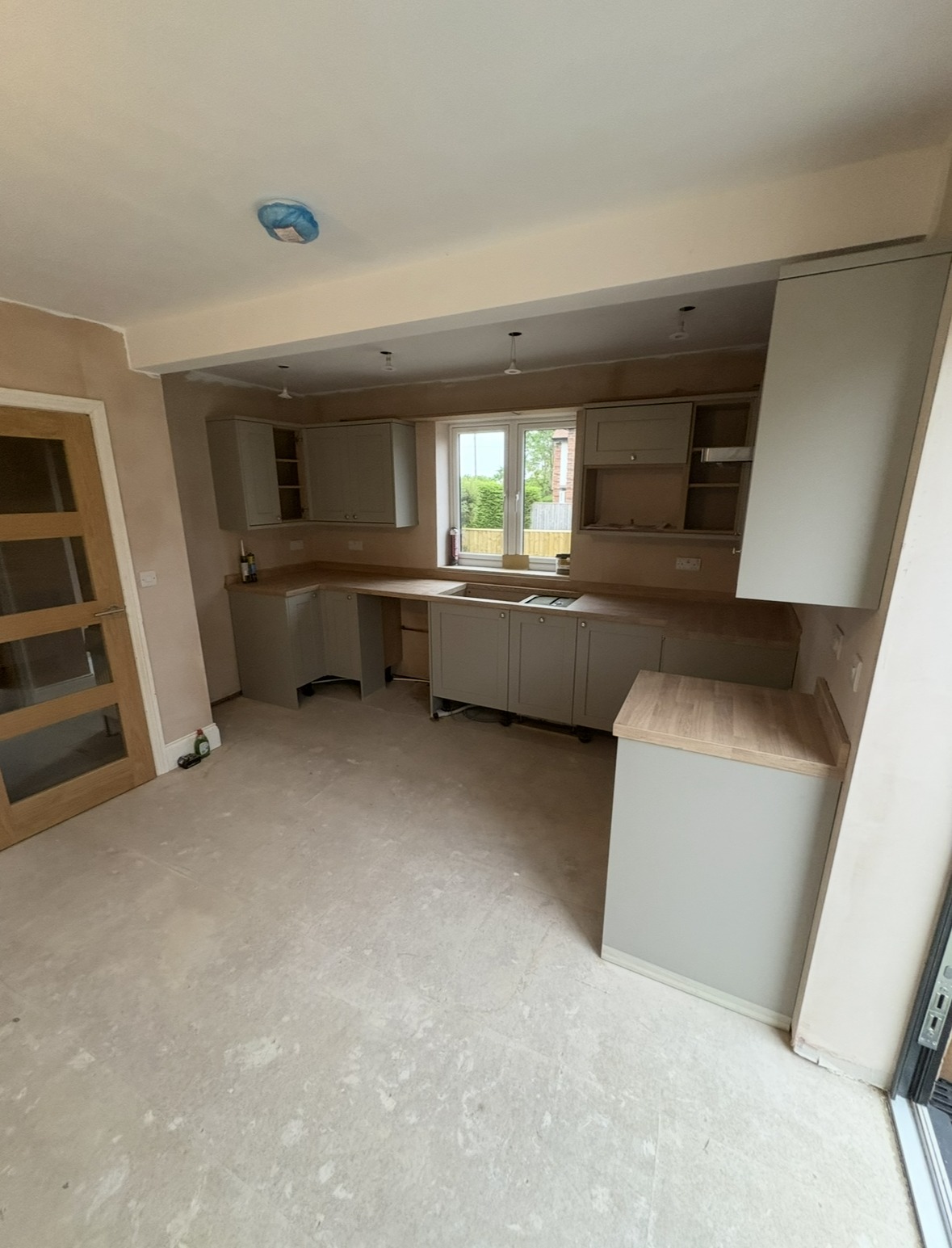 Sage green shaker kitchen fitting in progress